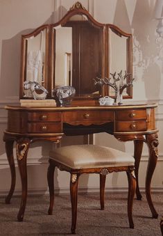 an antique dressing table with mirror and stool