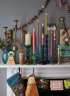 a mantle with candles and christmas stockings on it