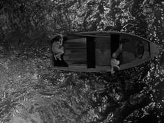 an aerial view of a boat in the water with two people on it's side