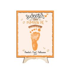 an orange and white sign that says sweeter than pumpkin pie with a foot print on it