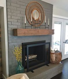 the fireplace is painted gray and has candles on it, along with a basket full of flowers