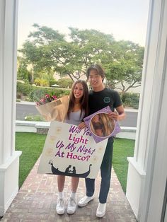 two people are holding up a sign that says, what's the light up night at taco?