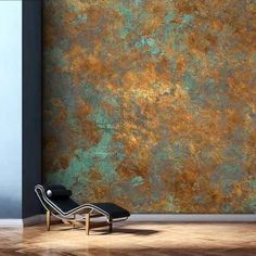 a chair sitting in front of a wall with gold paint on it