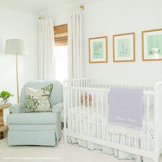 a baby's room with a crib, chair and pictures on the wall