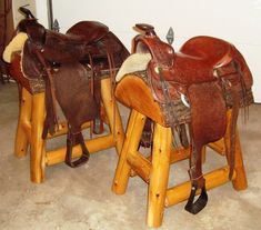 three wooden stools made to look like horses with saddles on them, sitting in a room