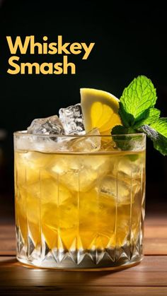 the whiskey smash is served in a glass with lemon wedges and mint garnish