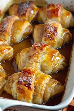 baked pastry items in a baking dish ready to be eaten with sauce on the side