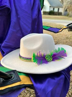 *cream felt wide brim hat with green brooch and feathers *black version is a Felt floppy hat for women with purple green and gold cording and a silver jeweled brooch .  Absolutely stunning! Never seen one like this at Mardi Gras before!  Mardi Gras wide brim hat, Mardi Gras fedora, Mardi Gras headpiece, Mardi Gras feather, Mardi Gras hat, Mardi Gras womens hat, Mardi Gras mirrored cowboy hat Mardi Gras Headpiece, Mardi Gras Hat, Jeweled Brooch, Mardi Gras Hats, Green Brooch, Womens Hat, Silver Jewels, Hat For Women, Wide Brimmed Hats