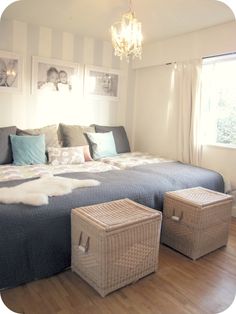 a bedroom with two twin beds and pictures on the wall above them, along with wicker storage baskets