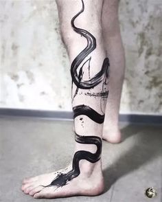 a man's leg with a black and white tattoo design on the bottom of it