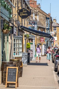 people walking down the sidewalk in front of shops