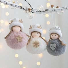 three christmas ornaments hanging from a string with lights in the background and snowflakes