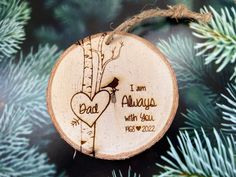 a wooden ornament hanging on a tree branch with the words, i am always with you