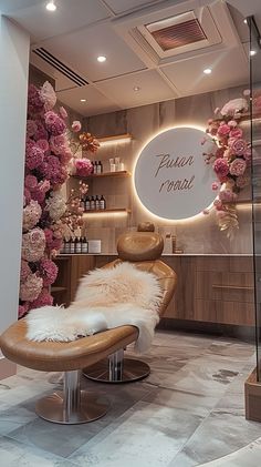 the interior of a beauty salon with pink flowers on display and a fur bench in front of it