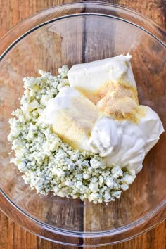 whipped cream and other ingredients in a glass bowl on a wooden table, top view