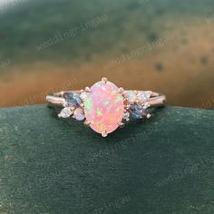 an opal and diamond ring on top of a wooden table