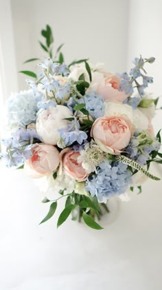 a bouquet of blue and white flowers in a vase