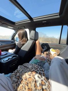 two people sitting in the back seat of a vehicle