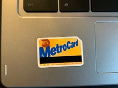 a laptop computer with a metro card sticker on it