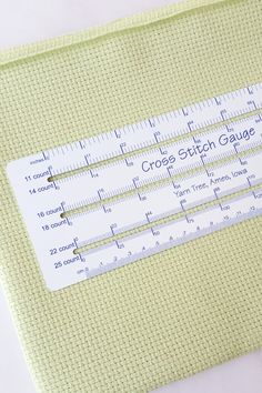 a ruler sitting on top of a table next to a piece of paper that says croche stitch gaug