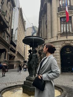 a woman standing in front of a fountain