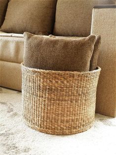 a basket sitting on the floor next to a couch