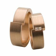 two gold wedding bands with a diamond in the middle