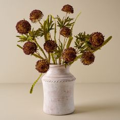 a white vase filled with flowers on top of a table