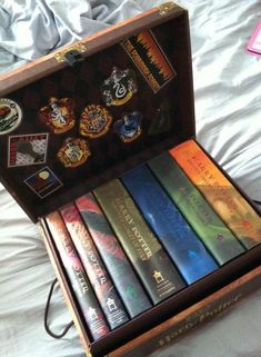 a wooden box filled with books on top of a bed