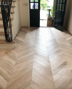 an empty room with wooden floors and stairs