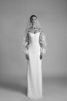 a woman in a wedding dress standing with her hands on her hips and wearing a veil