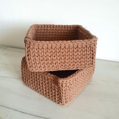 two knitted baskets sitting on top of a white table