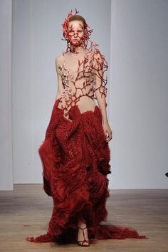 a woman in a red dress on the runway