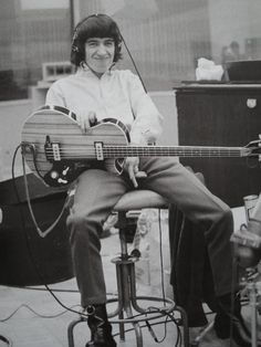 a man sitting on top of a chair holding a guitar