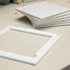 four square white frames sitting on top of a table