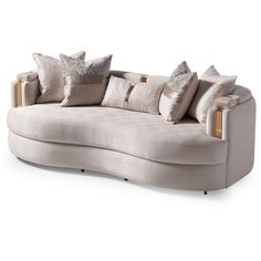 a curved couch with many pillows on it's back and sides, sitting in front of a white background