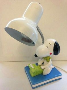 a snoopy lamp sitting on top of a blue book