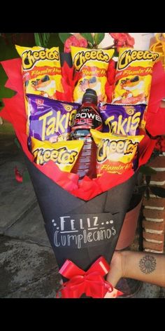 a person holding a bouquet of chocolates and candy