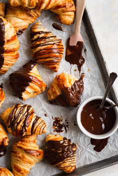 chocolate covered croissants and pastries on a baking sheet