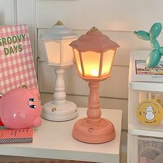 a pink pig lamp sitting on top of a white table next to a pink pig figurine