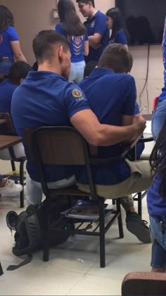 several people in blue shirts sitting at desks