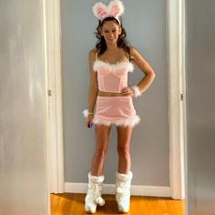 a woman in bunny ears and pink dress posing for the camera with her hands on her hips