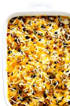 a casserole dish filled with cheese and black olives