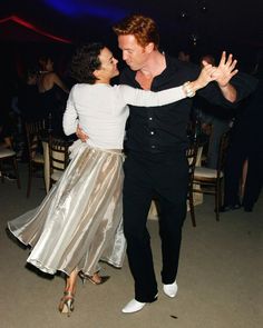 a man and woman dancing together at a party