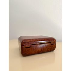 an old wooden box sitting on top of a table next to a white wall in the background