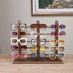 several pairs of sunglasses are displayed on a wooden stand