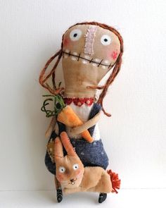 a stuffed doll is holding carrots in its arms