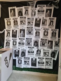 a bunch of wanted posters are hanging on the wall behind a white cube that has been placed in front of it