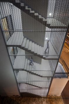 an overhead view of people walking up and down the stairs in a building at night