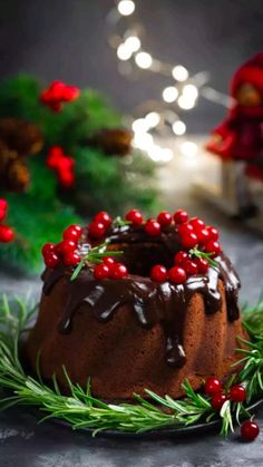 a bundt cake covered in chocolate frosting and cranberries on a table